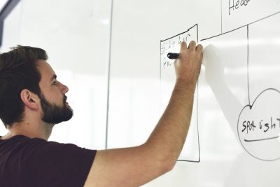 man writing on white board